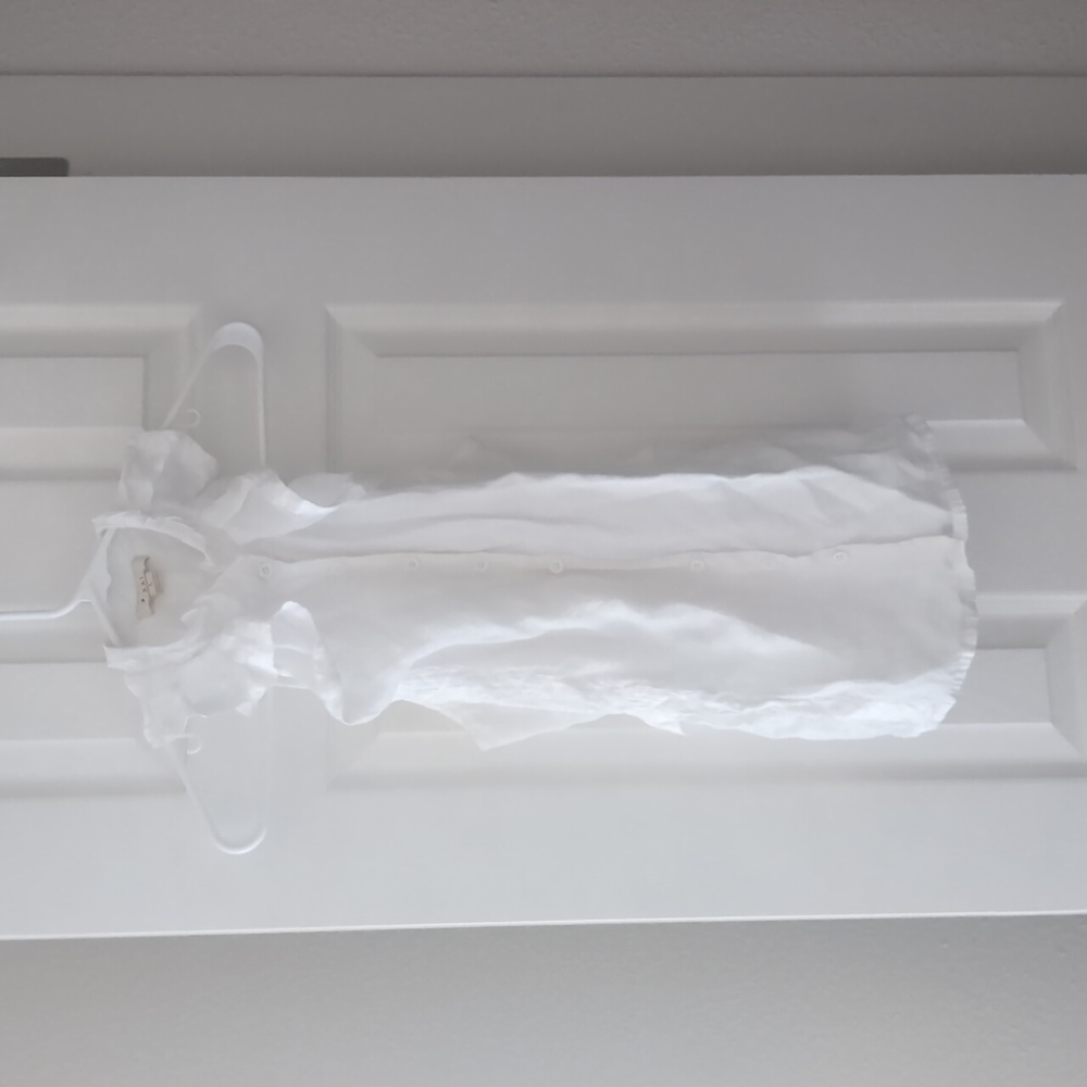 Sleeveless white blouse with ruffles